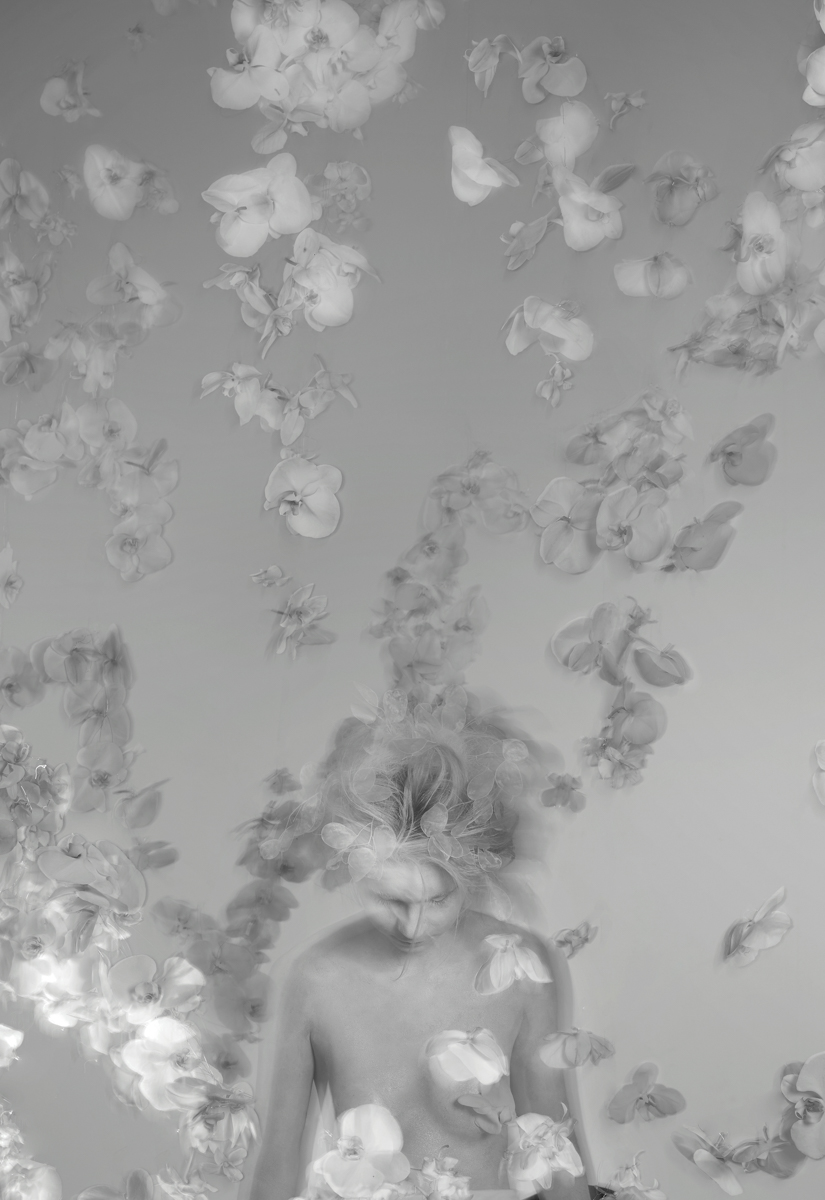 Flower installation with white floating orchids around a girl painted in white body black and white photo by Florist and set designer in Shanghai China Daria Bokova